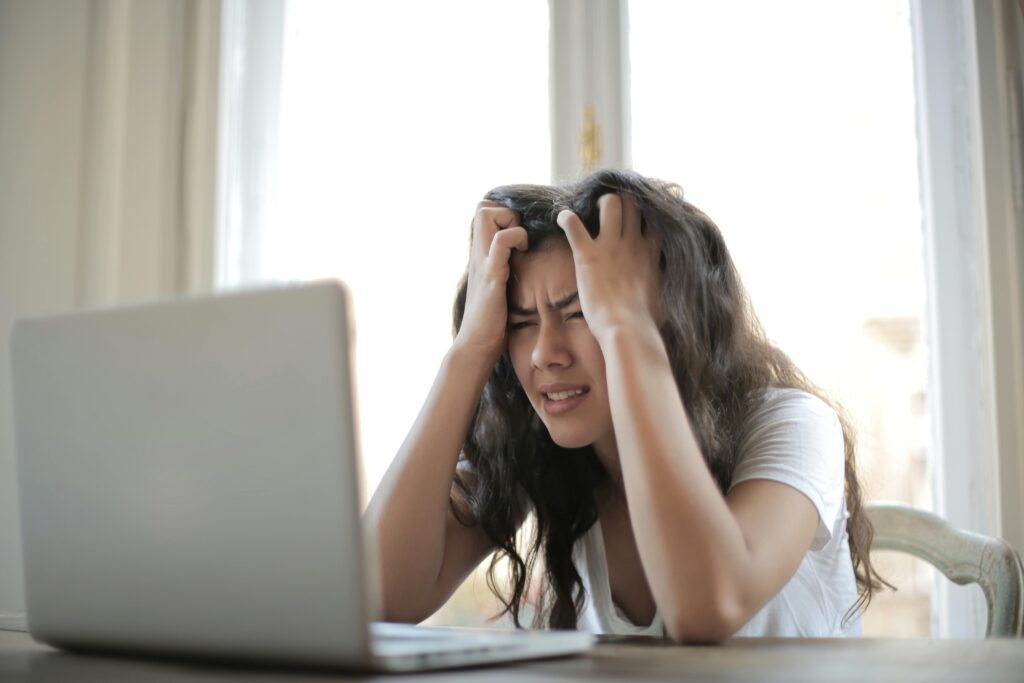 Mujer frustrada que lucha con el estrés del trabajo remoto y los desafíos digitales en el interior.