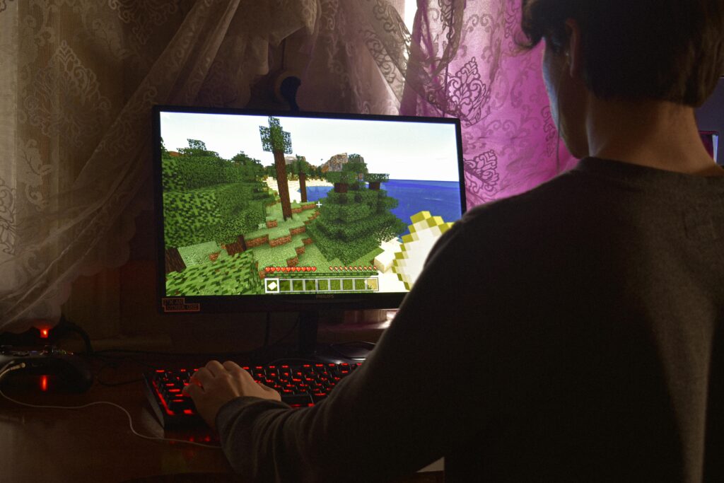 Un joven que juega intensamente un videojuego de PC en el interior. Capturar la esencia de la tecnología y la concentración.