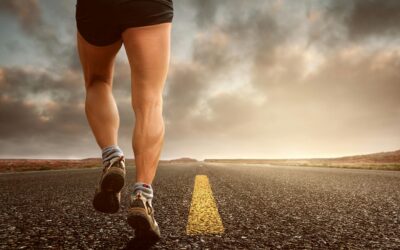 Runner's legs on a road during a sunset, symbolizing endurance and outdoor fitness training.