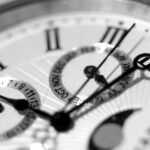 Detailed black and white shot of an elegant watch face showcasing timekeeping elements.